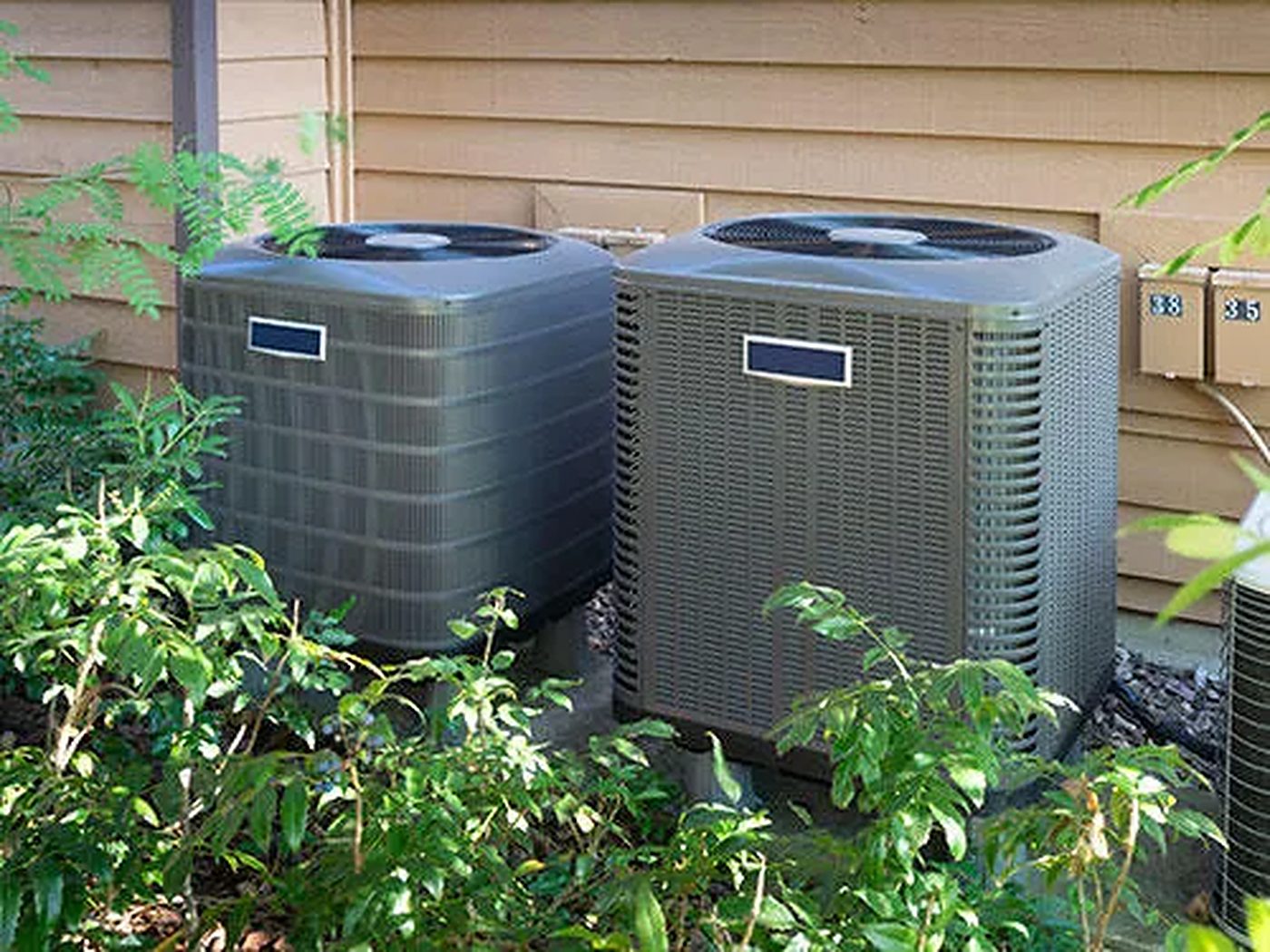 Two residential air conditioning condenser units beside a home, serviced by AAA Air Conditioning Inc. in Victoria, TX